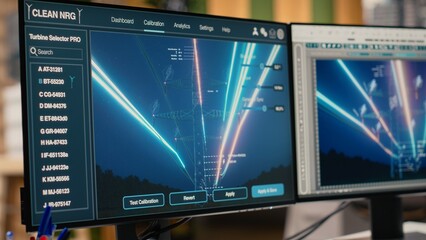 Digital power lines analytics dashboard displays performance data, supporting smart grid optimization. Workstation in office used to analyze sensor data from clean energy generator transmission tower