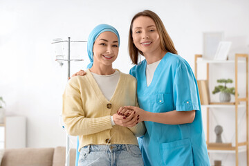 Young woman undergoing chemical therapy course with nurse at home. Brain cancer concept