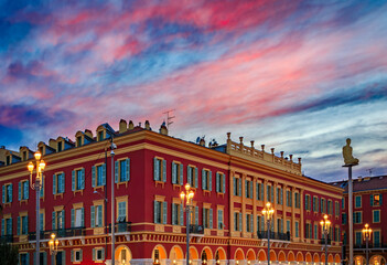 Fiery sunset above the colorful buildings in Place Massena square, Nice, France