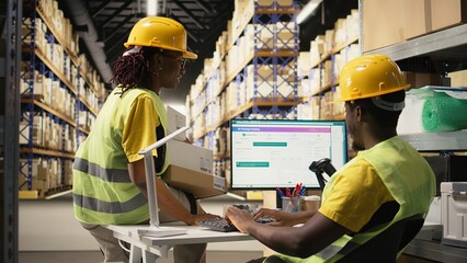 Warehouse operations team managing incoming shipment of merchandise, monitoring tracking software...