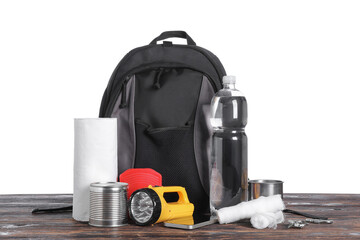 Naklejka premium Emergency backpack with necessities on table against white background