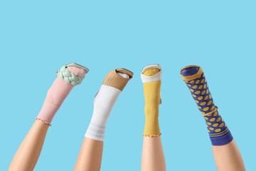 Fototapeta na wymiar Female legs in stylish shoes with socks on blue background