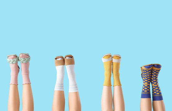 Female legs in stylish shoes with socks on blue background