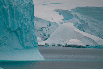 Massive Iceberg in Antarctica Sharp Edges with Untouched Snow Covered Mountains and Glaciers Behind...