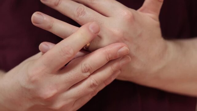 Close-Up Slow Motion of Man Nervously Fidgeting with Wedding Ring on Finger