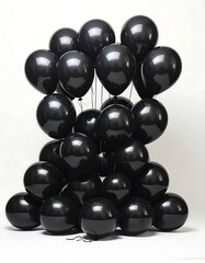 Bunch of glossy black balloons clustered against a bright background