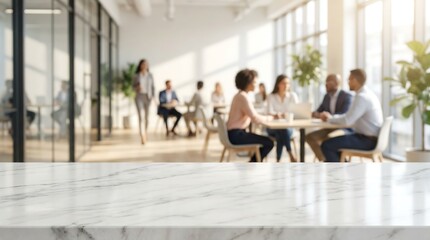 A brightly lit modern office space features people collaborating around a table with a blurred foreground marble countertop and large windows high quality