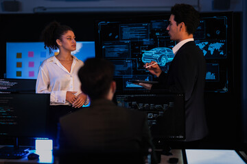 Automotive engineer presenting electric car design on large digital screen. Technical team analyzing vehicle aerodynamics and engine performance data in high-tech laboratory.