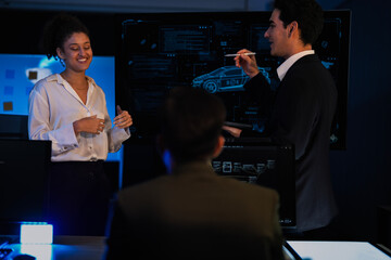 Autonomous driving software developers discussing car AI navigation system. IT specialist explaining self-driving vehicle simulation data to colleagues in modern control room.