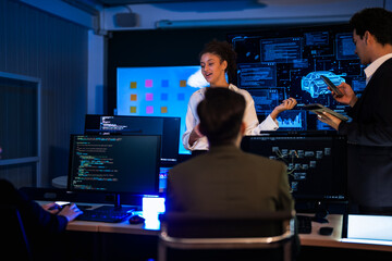 Autonomous driving software developers discussing car AI navigation system. IT specialist explaining self-driving vehicle simulation data to colleagues in modern control room.