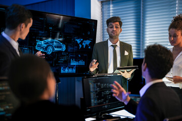 Automotive executives discussing electric car market strategy. Business leadership team analyzing vehicle sales data and future design trends in modern night office.