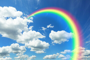Bright colorful rainbow and clouds in blue sky