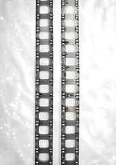 Obraz premium Two vertical vintage film strips with sprocket holes and blank square frames on a bright textured background, evoking nostalgic minimalism