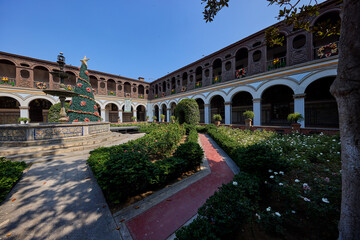 Fototapeta premium Silence and sunlight in the heart of Lima. The Convento de Santo Domingo offers a peaceful escape from the bustling city streets, where centuries of history are preserved in every carved wooden 