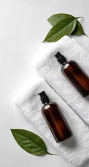 Two brown bottles with pump dispensers sit on white towels with green leaves.