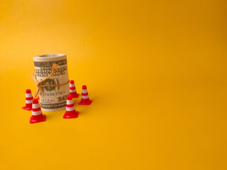 The rolled-up hundred-dollar bills represent money or investments, while the surrounding mini...