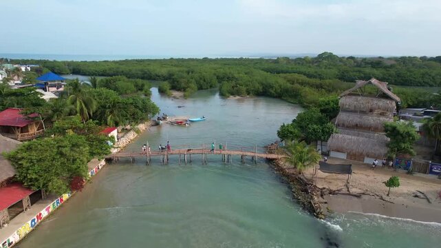 Aerial view of a small coastal village in colombia with a mangrove forest and the caribbean sea