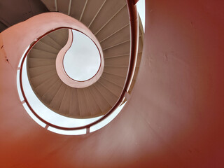 Spiral metal staircase with bright orange and white color.