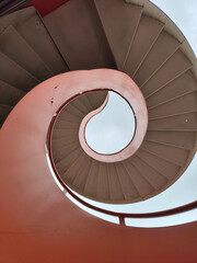 Spiral metal staircase with bright orange and white color.