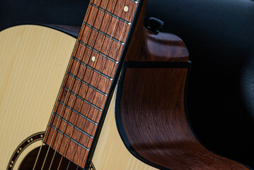 Close-up detail of an acoustic guitar body with wooden texture and strings, captured in low light...