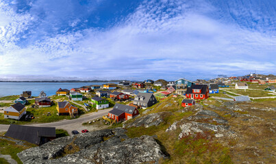 Typical architecture of Greenland capital Nuuk with colored houses located near fjords and icebergs.