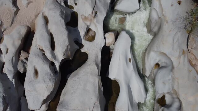 Aerial view of Badillo River in Valledupar, Colombia, with people swimming among iconic giant white rocks.