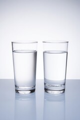 Two identical glasses showcasing clear and cloudy water side by side illustrating filtration benefits