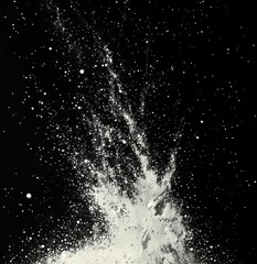 Obraz premium White particles exploding and scattering in various directions against a black background creating a dynamic and energetic visual effect