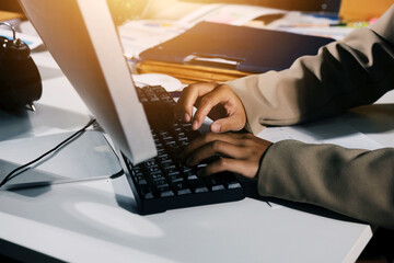 business documents on office table with tablet, smart phone and laptop and two colleagues discussing data
