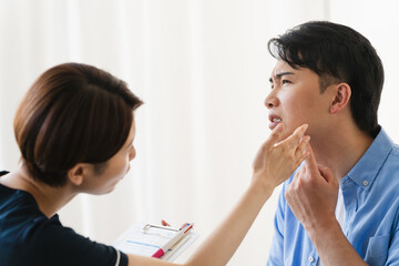 ひげ脱毛する若い男性をカウンセリングをするセラピスト