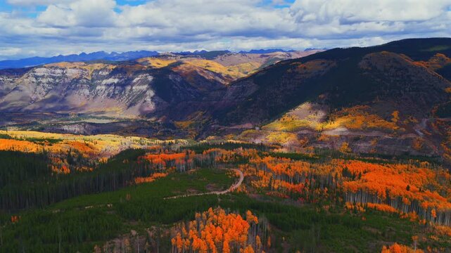 Mount of the Holy Cross Wilderness Sawatch Gore Range Minturn Red Cliff Gilman Vail parallax aerial drone Fall Autumn cloudy morning Rocky Mountains Colorado colorful Aspen trees windy dirt road pan