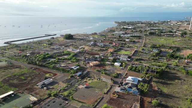 lahaina hawaii aerial view (small down devastated by fire cleaning and rebuilding) cars driving on road clear sunny day tropical pacific island travel tourism destination (burn disaster aftermath)