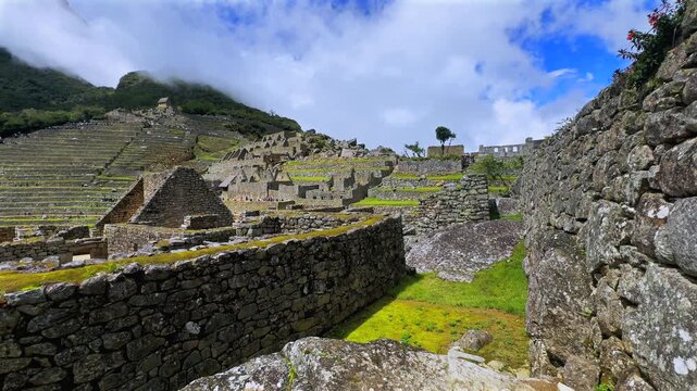 Shihuahuaco tree Machu Picchu sunny blue sky clouds morning Peru Per&uacute; aerial drone mount Huayna Picchu rainy season lush green Peruvian Andes Inca Temple Sanctuary jungle stone work terrace pan left