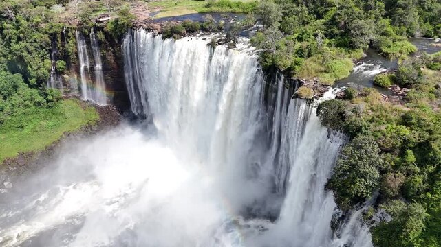 Cinematic aerial perspective of the powerful white water curtain at Calandula Falls, Malanje, Angola, Africa, surrounded by lush tropical greenery