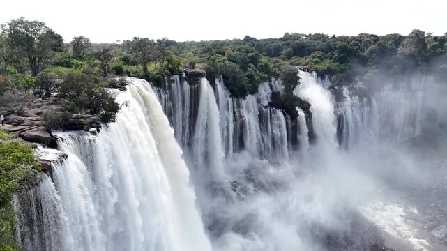 A close-up aerial through the rising mist and powerful spray of the Calandula Falls, highlighting the dramatic force of the Lucala River Angola Africa drone footage