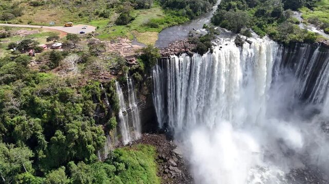 Breathtaking drone footage of Calandula Falls, one of Africa's largest and most powerful waterfalls, cascading down the lush cliffs of Malanje Province High-angle aerial perspective