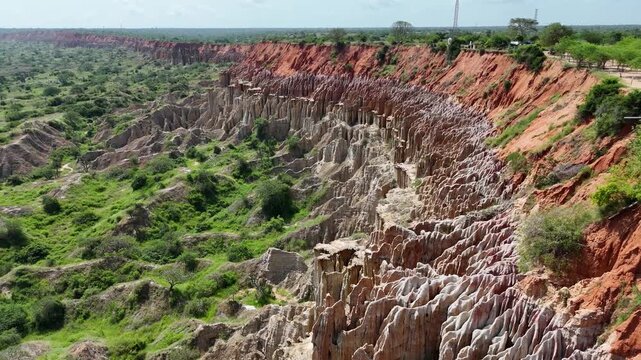 Cinematic drone aerial close up over the dramatic red clay formations of Miradouro da Lua (Viewpoint of the Moon) in Belas Municipality, Luanda Province, Angola, Africa