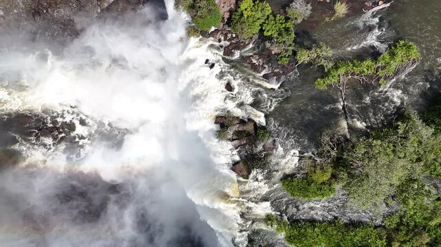Cinematic drone footage of the powerful Calandula Falls, one of Africa largest waterfalls by volume, showcasing the mist and lush green surroundings aerial top down