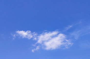 Wispy white clouds drift across a clear blue sky, creating a calm and open atmosphere.