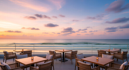 Obraz premium Elegant seaside restaurant terrace overlooking the ocean during golden sunset, featuring modern furniture and refined table settings, perfect for luxury travel, vacation, and fine dining visuals
