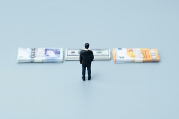 Businessman looking at stacks of cash money. Investment, profit, and financial decision making concept.