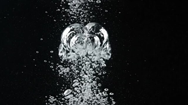 Rising water bubbles erupting against a dark black void background.