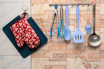 set of kitchen utensils and a potholder on the wall