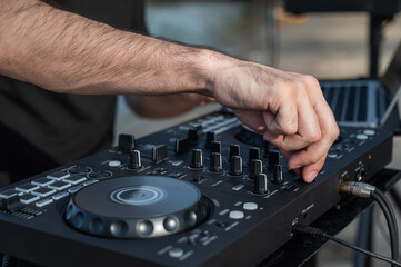 Close up of DJ's hands while working outdoors. 