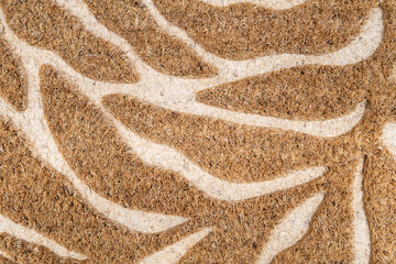 Artistic leaf pattern carved on natural coir fiber texture background. home interior, floor covering, and nature-inspired design themes.