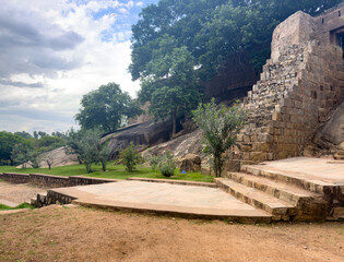 Thirumayam Fort in Pudukkottai district, Tamil Nadu, showing ancient stone fortification walls, steps, and cannon ramp with trees.