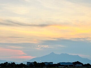 Sarawak, Malaysia - 15 September 2024: A scenic landscape view of a prominent mountain silhouette during a soft sunset.