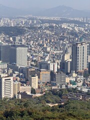 Fototapeta premium Seoul, South Korea - 24 October 2024: A high-altitude, dense urban view of the sprawling city of Seoul, featuring a mix of modern high-rise apartments and traditional buildings.