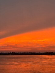 Fototapeta premium A wide-angle landscape shot of a dramatic sunset over a wide river.