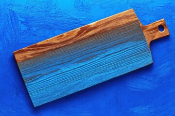 Crafted wooden cutting board rests on vibrant blue surface enhancing kitchen aesthetics and functional design